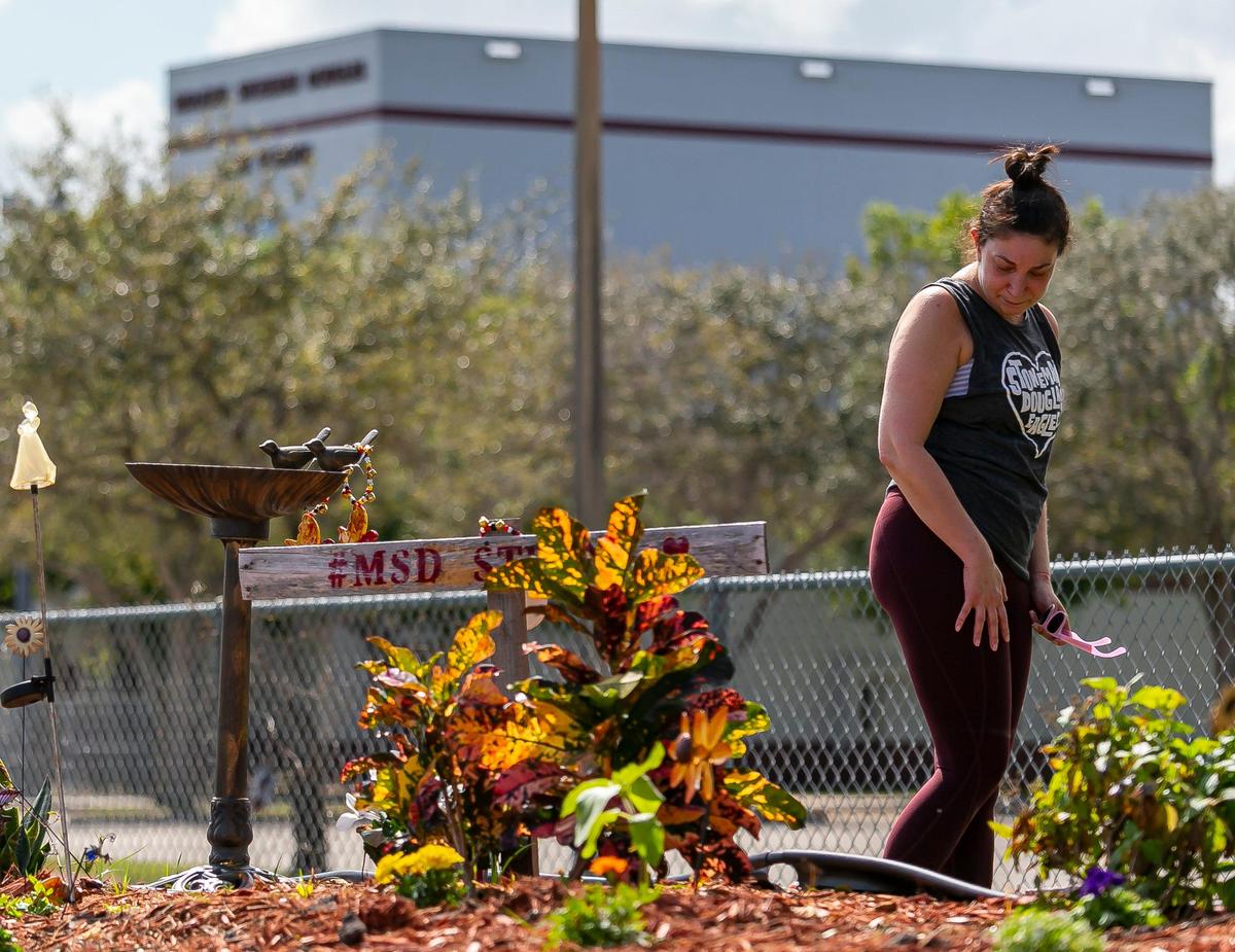 Stacey Faber visits a makeshift memorial outside of Marjory Stoneman Douglas High School on Friday, February 14, 2020, during the two-year anniversary of the Parkland shooting where 17 victims were killed.