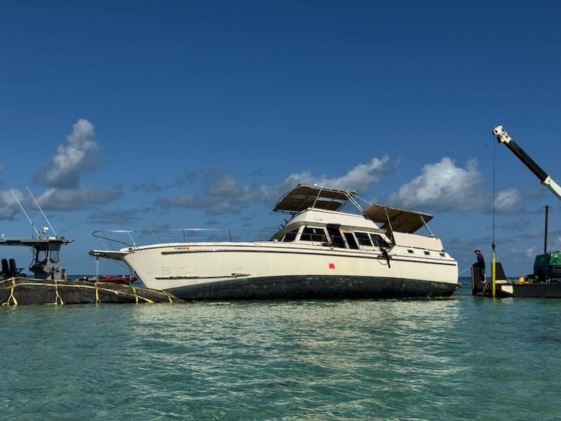 Crews work to remove a 65-foot cabin cruiser from Sisters Creek in Marathon in the Middle Florida Keys. It was one of hundreds of derelict boats pulled from Monroe County waters in 2025.