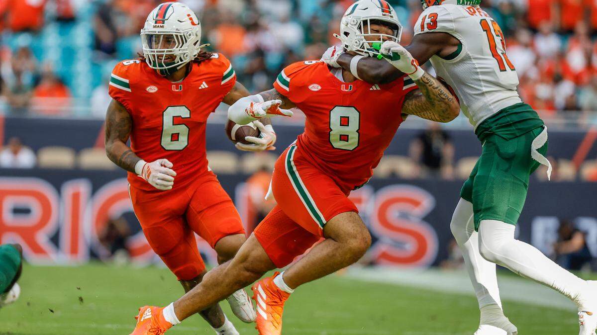 Miami Hurricanes running back Damien Martinez (6) carries the ball as tight end Elijah Arroyo (8) blocks Florida A&M Rattlers wide receiver Goldie Lawrence (13) in the first half at Hard Rock Stadium in Miami Gardens, Florida, on Saturday, September 7, 2024.