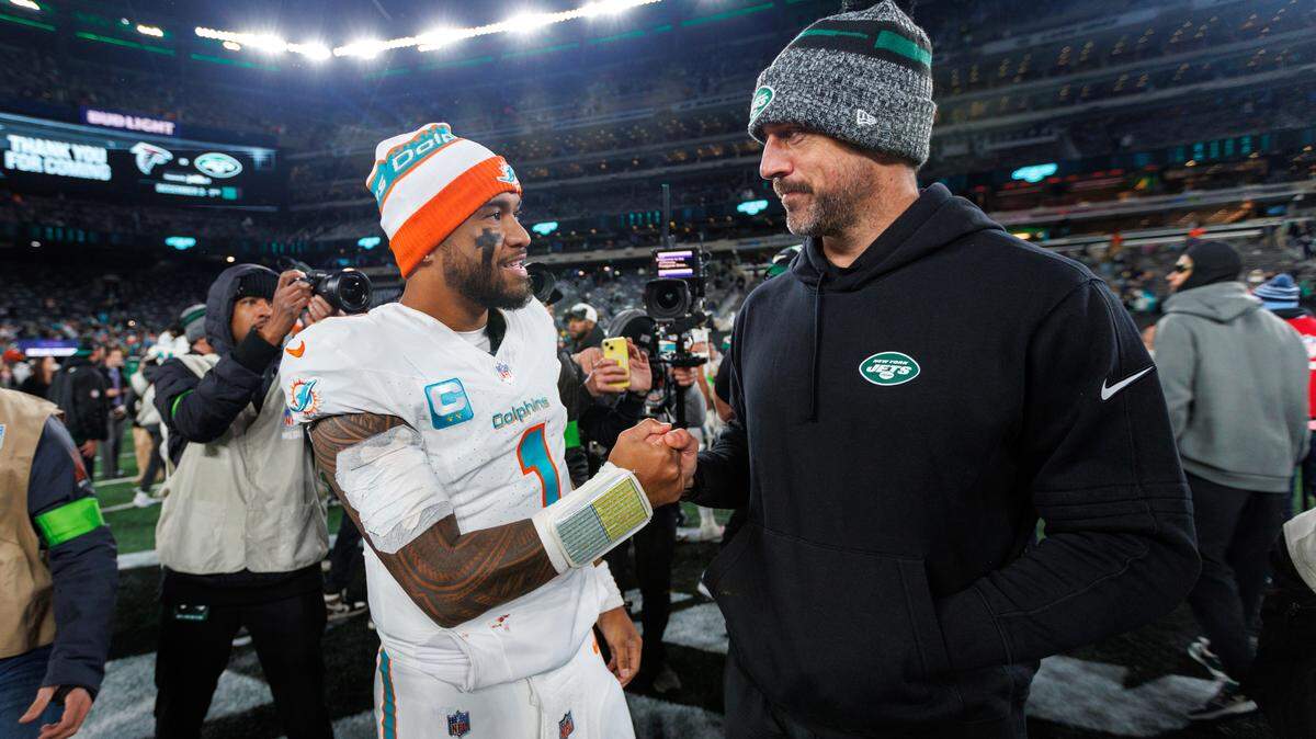 Miami Dolphins quarterback Tua Tagovailoa (1) interacts with New York Jets quarterback Aaron Rodgers (8) after the Dolphins 34-13 win over the Jets during an NFL football game at MetLife Stadium on Friday, Nov. 24, 2023 in East Rutherford, New Jersey. (Rodgers did not play because of an injury).