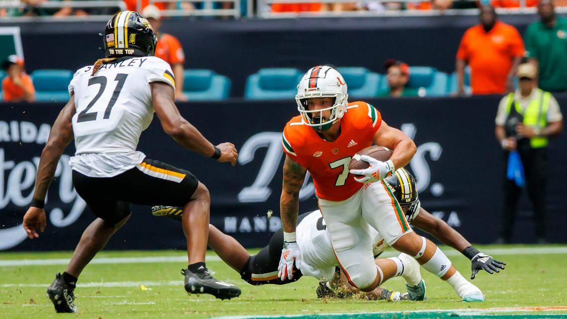 Miami Hurricanes wide receiver Xavier Restrepo (7) runs with the football against Southern Miss Golden Eagles safety Jay Stanley (21) and teammate TQ Newsome (35)  during the second quarter of an NCAA non conference game at Hard Rock Stadium on Saturday, September 10, 2022 in Miami Gardens, Florida.