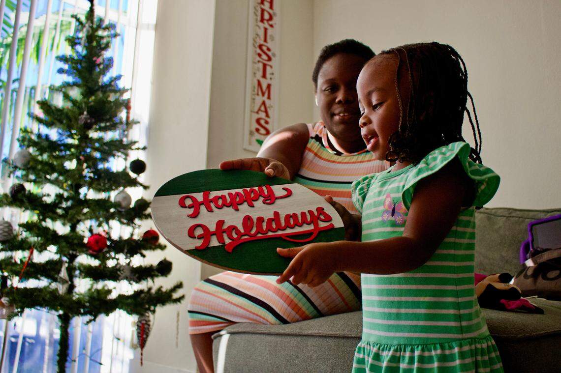 Two-year-old Ro’Niyah Frederick decorates for the holidays with her mother, Tajjii Ferguson.