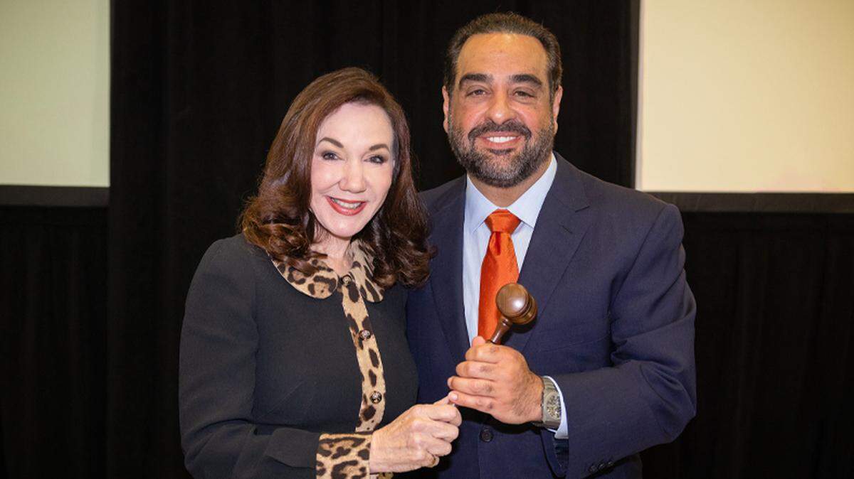The former chair of the University of Miami Board of Trustees, Laurie Silvers, poses with a gavel and the new chair of the board, Manny Kadre, on Thursday, May 30, 2024.