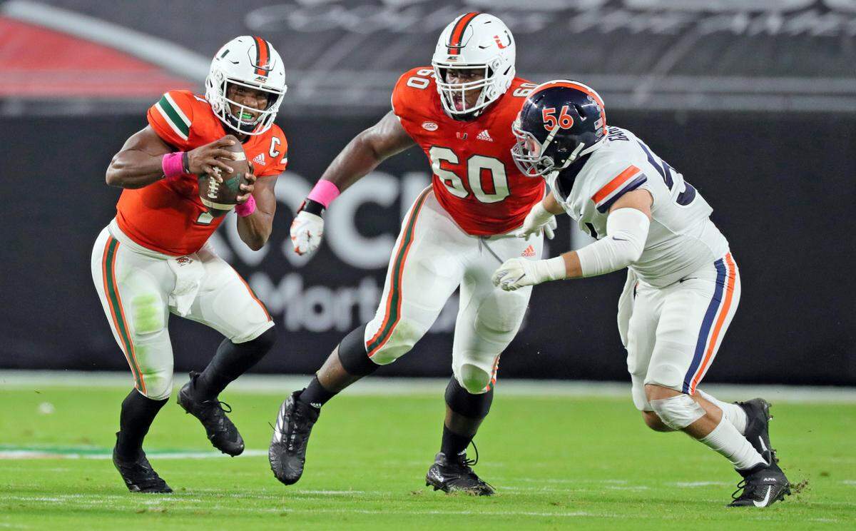 Miami Hurricanes quarterback D’Eriq King (1) scrambles as offensive lineman Zion Nelson (60) clears a path against a Virginia Tech defender at Hard Rock Stadium in Miami Gardens, Florida, Saturday, October 24, 2020.