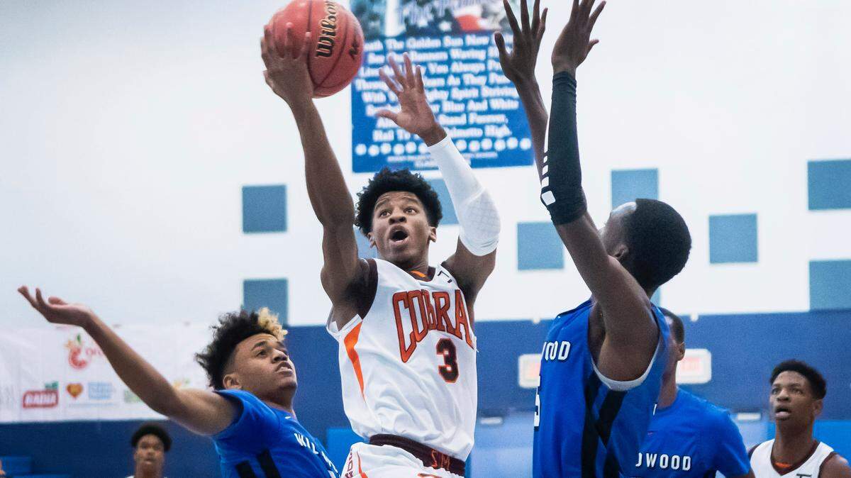 South Miami’s Toru Dean eludes two Wildwood defenders on his way to a driving layup. Dean led the Cobras to a first round victory with 28 points in Thursday’s opening round of the Junior Orange Bowl Basketball Classic at Palmetto High School.