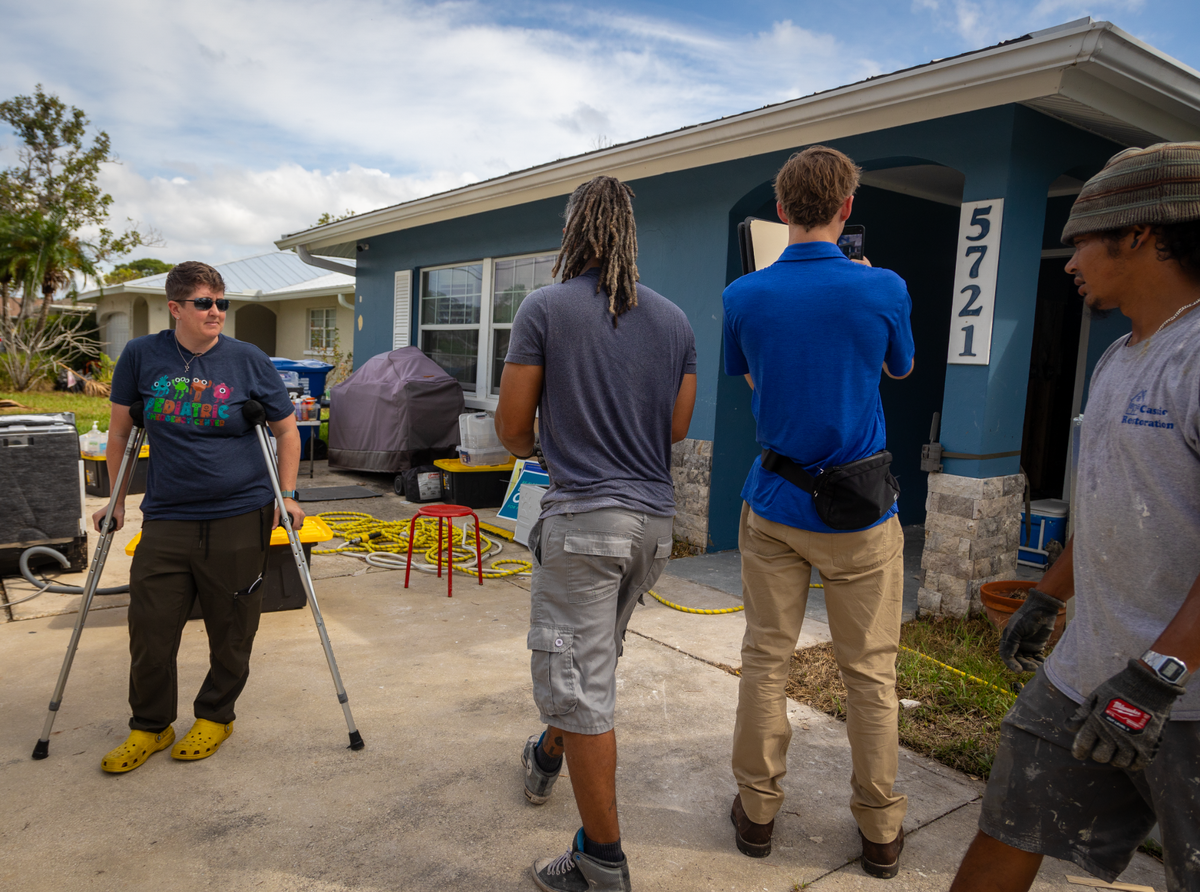 Contractors work on tearing out the dry wall of Dr. Meghan Martin’s St.Petersburg home and an independent adjuster takes photos to send to FEMA on Oct. 3.