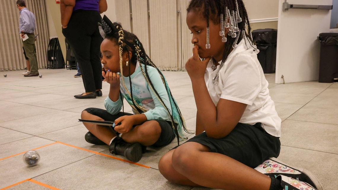 Faith Denise Ariel Chapman, left, 9, fourth grader, and Courtney Faith Nelson, 9, third grader, watch the robot they programmed travel the pathway at the Fab Lab launched at the Phichol Williams Community Center in Homestead on Wednesday, Jan. 17, 2024.