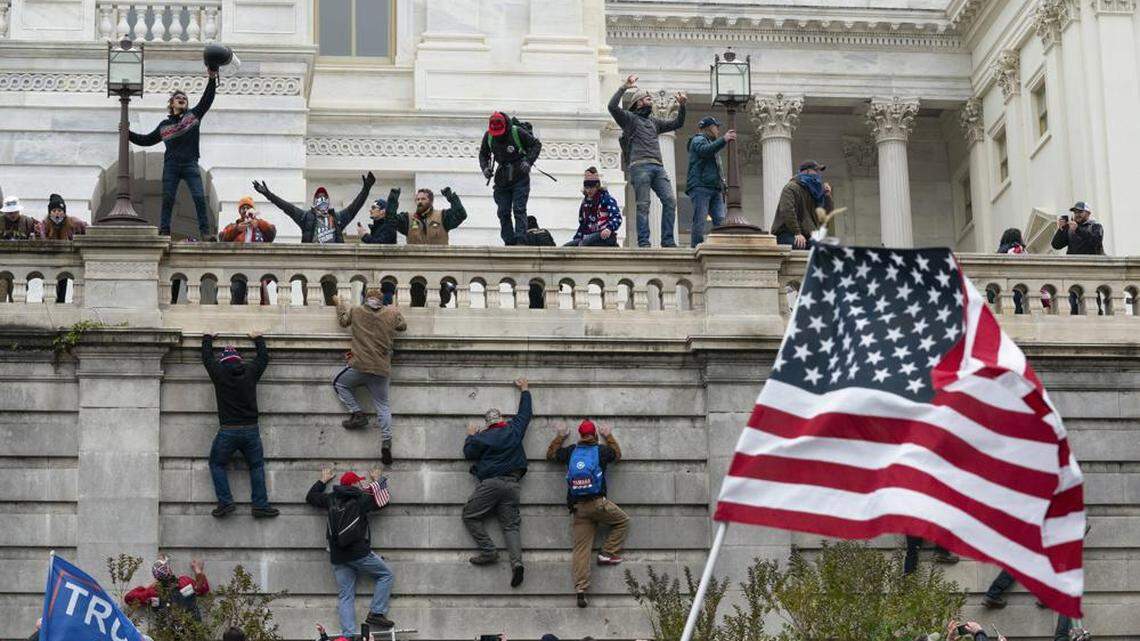 Rioters scale a wall at the U.S. Capitol on Jan. 6, 2021, in Washington.