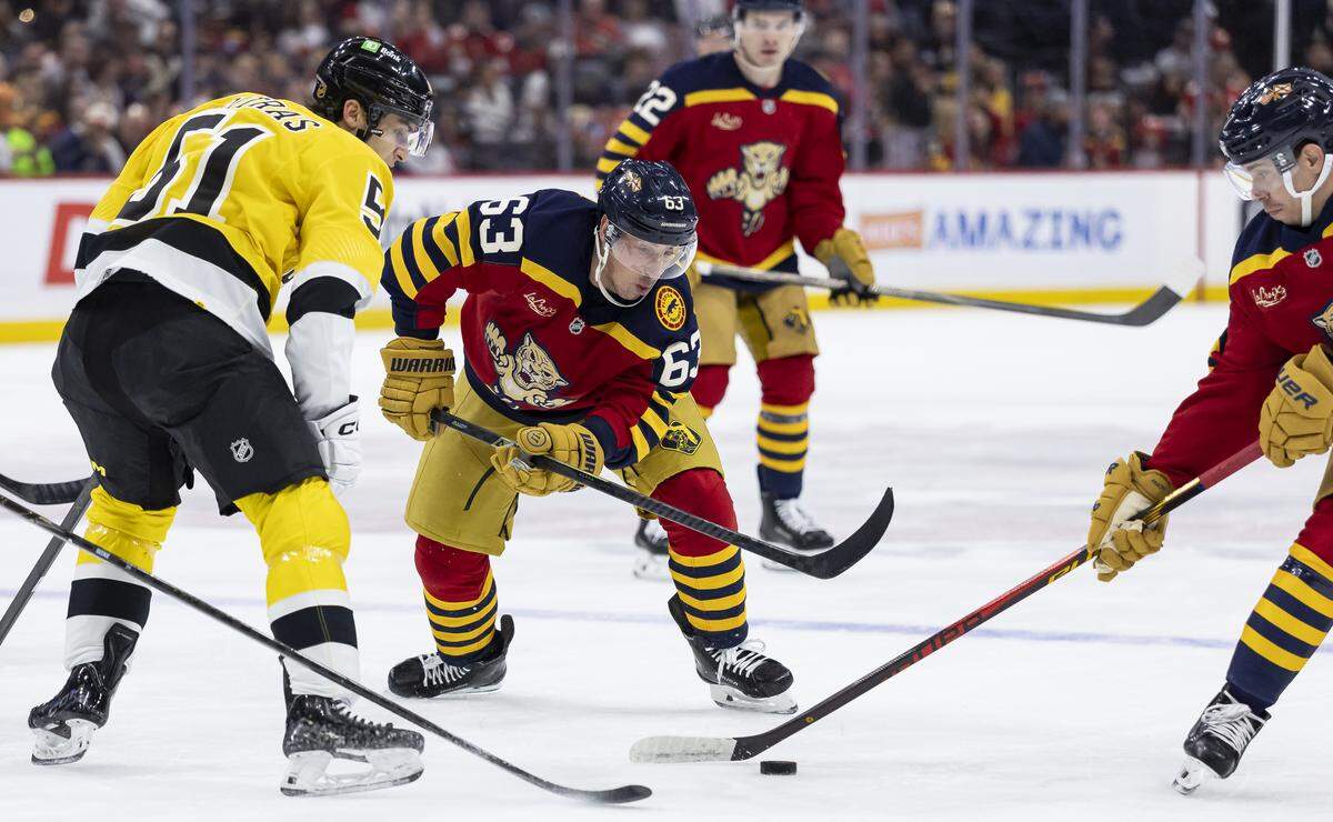 Florida Panthers left wing Brad Marchand (63) and Boston Bruins center Matthew Poitras (51) compete for the puck in the first period of their NHL game at the Amerant Bank Arena on Wednesday, Feb. 4, 2026, in Sunrise, Fla.