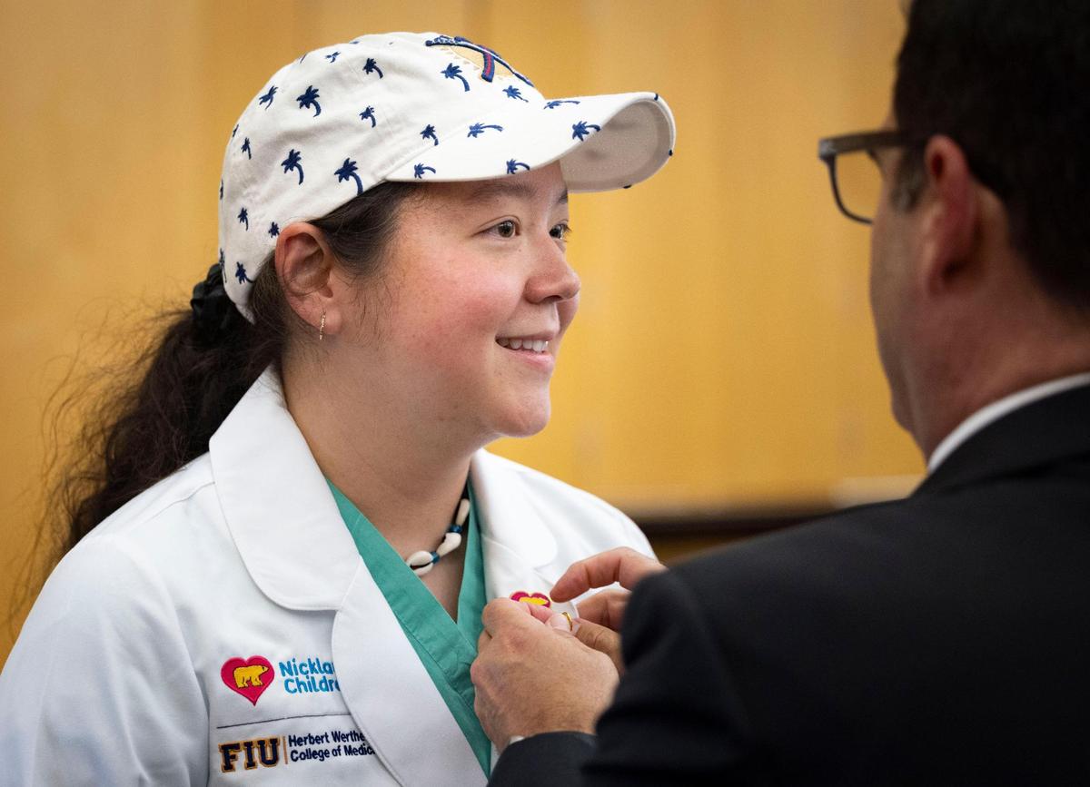 Jennifer Thompson, attending physician at Nicklaus Children’s and graduate of FIU, receives a pin before a ceremony announcing the launch of a new clinical, research and academic collaboration between FIU and Nicklaus Children’s Health System on Monday, May 19, 2025, at Florida International University campus in Miami, Fla.