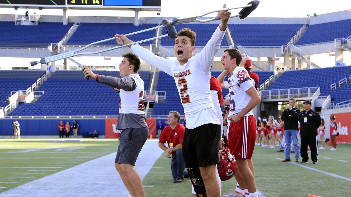 An injured Cardinal Gibbons quarterback Nik Scalzo reacts to game action from the sidelines as Cardinal Gibbons plays North Marion in the Florida High School Athletic Association Class 5A State Championship at Camping World Stadium in Orlando on Friday, December 7, 2018.