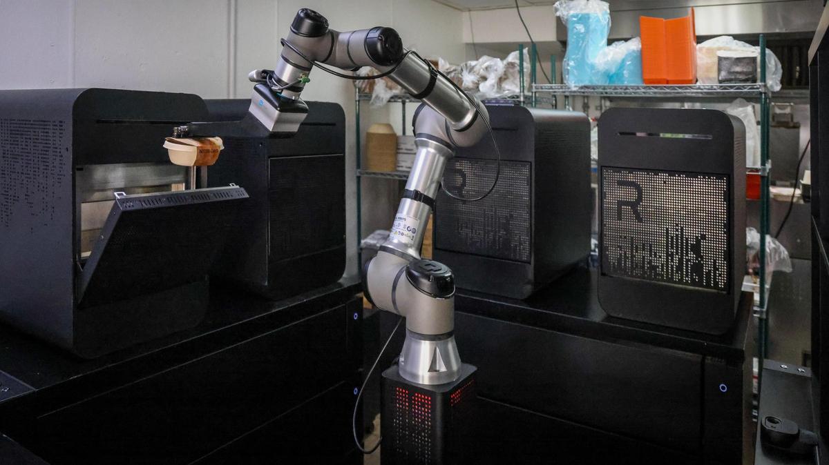The robot chef from Better Days Robotic Kitchens puts an order into one of the four ovens at the Coral Gables delivery spot run by husband and wife team Cem and Ece Kinay.