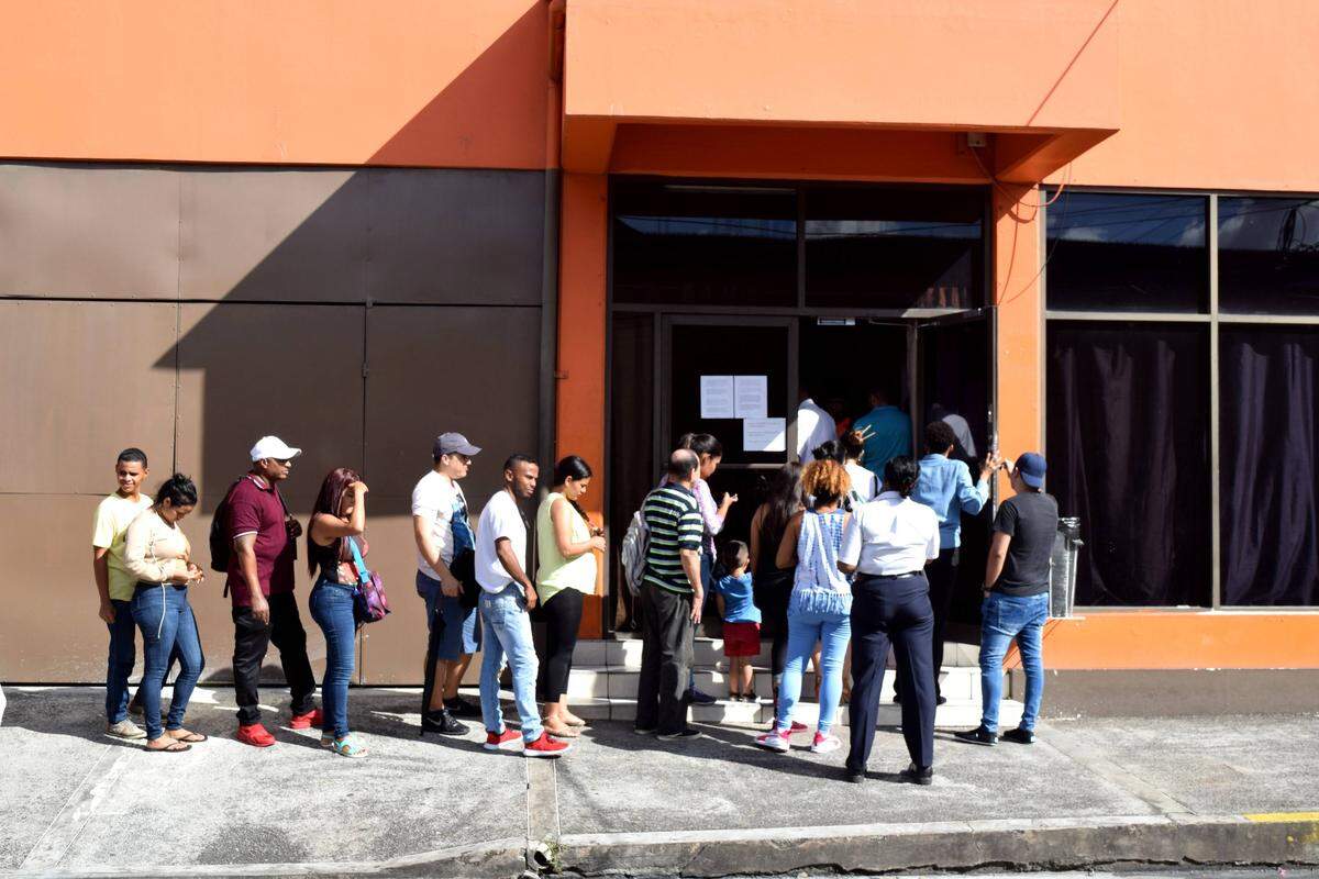 Migrants, mainly Venezuelans, wait outside of Living Water Community, an NGO that works with asylum seekers, in Port of Spain, Trinidad. The island is thought to be home to more than 40,000 Venezuelans, many of them living there as undocumented migrants.