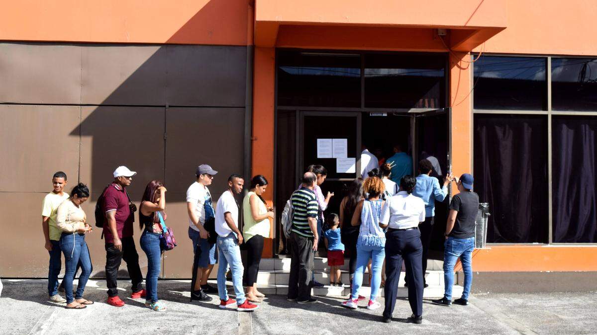 Migrants, mainly Venezuelans, wait outside of Living Water Community, an NGO that works with asylum seekers, in Port of Spain, Trinidad. The island is thought to be home to more than 40,000 Venezuelans, many of them living there as undocumented migrants.