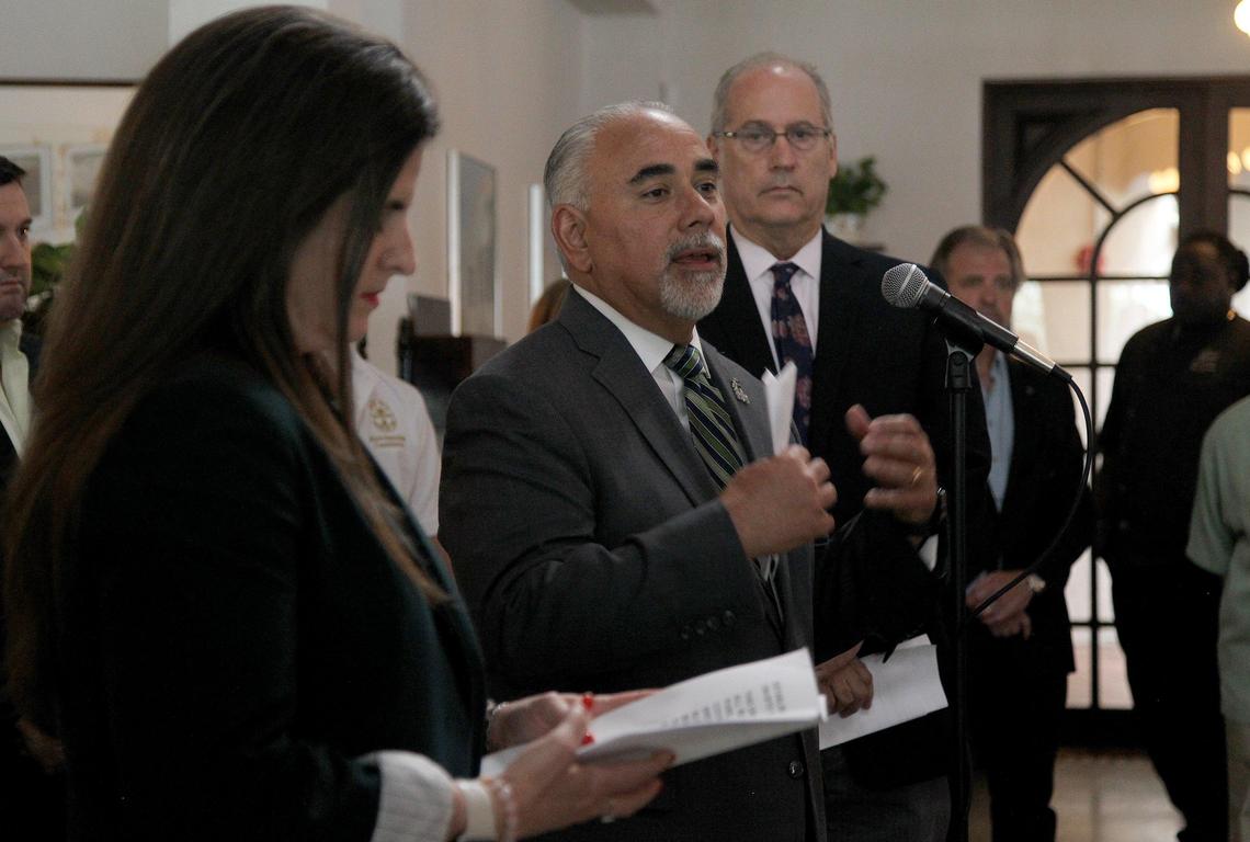 Miami Beach Manager Jimmy Morales is flanked by Jennifer Moon, deputy mayor of Miami-Dade County, and Miami Beach Mayor Dan Gelber, as he joins a group of elected officials from Miami-Dade County during the announcement at Joe’s Stone Crab restaurant on March 17, 2020, of a countywide closure on dine-in restaurants, bars and clubs, gyms and entertainment venues beginning Wednesday, March 18, due to the coronavirus pandemic.