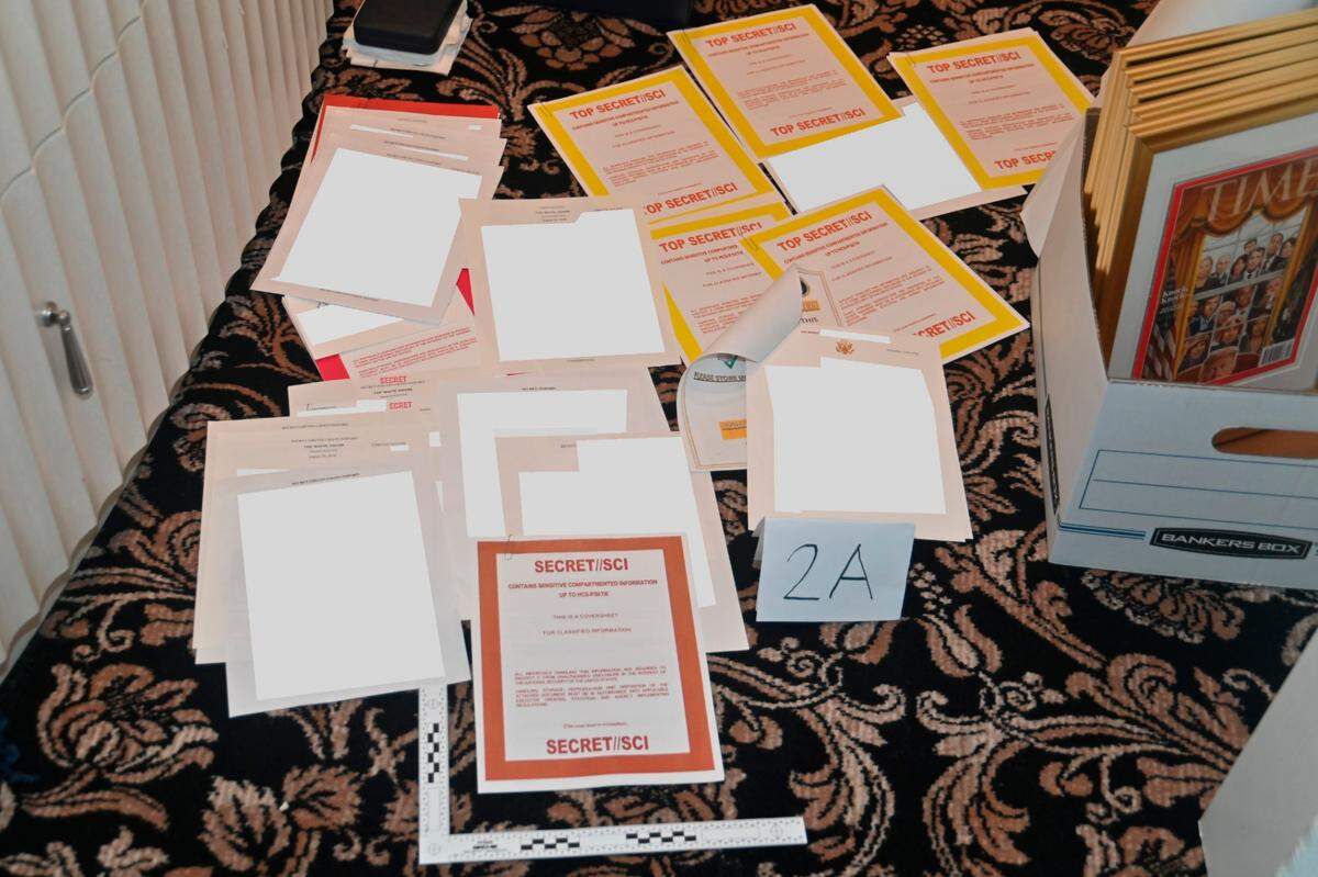 ARCHIVO - Esta imagen contenida en una presentación judicial del Departamento de Justicia el 30 de agosto de 2022, y parcialmente tachada por la fuente, muestra una foto de documentos incautados durante el registro del FBI del 8 de agosto en la mansión Mar-a-Lago del ex presidente Donald Trump. El registro por parte del FBI de la mansión de Donald Trump en la Florida dio lugar a un proceso paralelo con un maestro especial que este mes desaceleró una investigación penal y puso de manifiesto las tensiones latentes entre los fiscales del Departamento de Justicia y los abogados del ex presidente. La investigación sobre la presencia de información de máxima seguridad en Mar-a-Lago continúa. (Departamento de Justicia vía AP, Archivo)