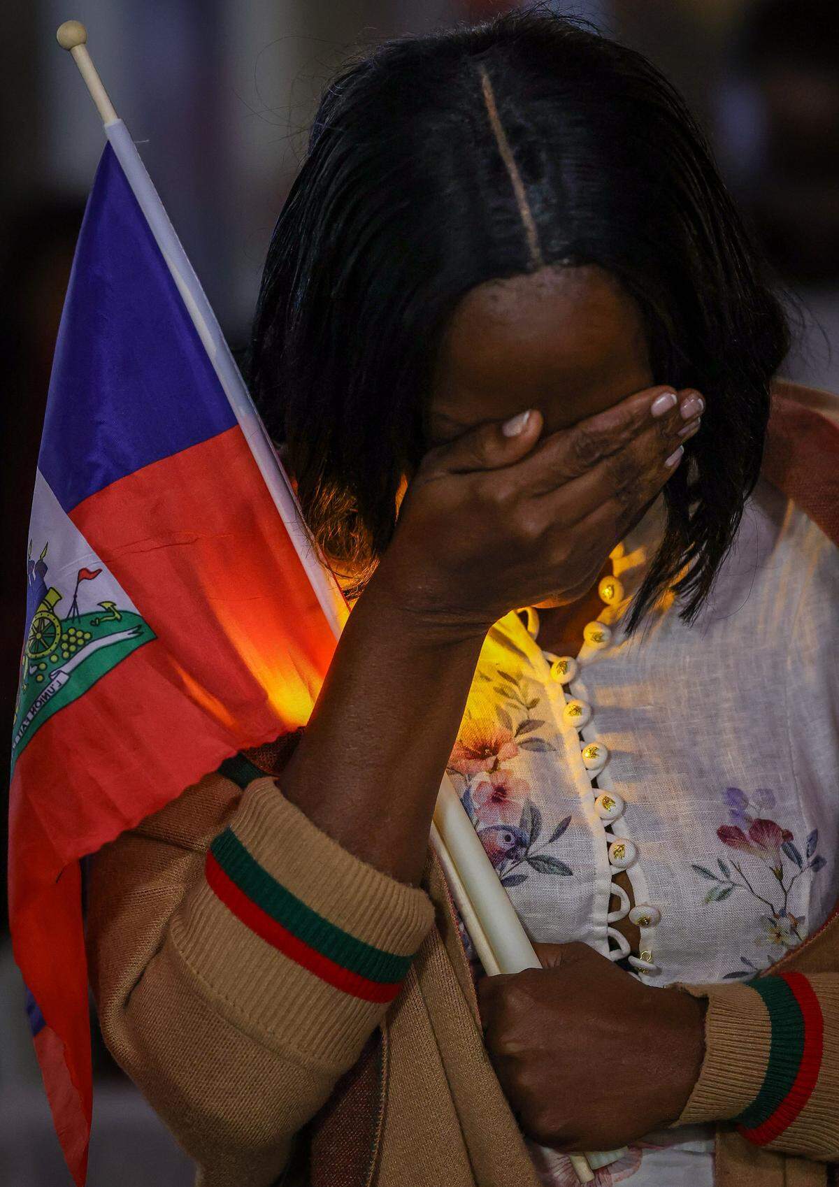 Linda Joseph, a community activist, shields her eyes while in prayer during the candlelight vigil as public officials from Miami-Dade County, the City of Miami and North Miami, along with community members, gathered for a TPS candle light prayer vigil at the Little Haiti Cultural Complex on Feb. 3, 2026, in Miami. The event, held in support of the local TPS community, included prayer, reflection and calls for unity and hope.