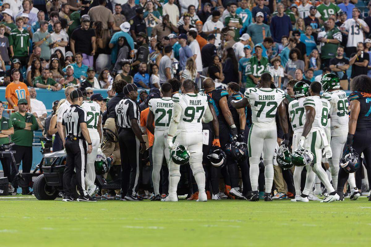 Miami Dolphins and New York Jets players gather around Dolphins wide receiver Tyreek Hill (10) as he is prepared to be carted off the field after suffering an injury during the second half of an NFL game at Hard Rock Stadium on Monday, Sept. 29, 2025, in Miami Gardens, Fla.