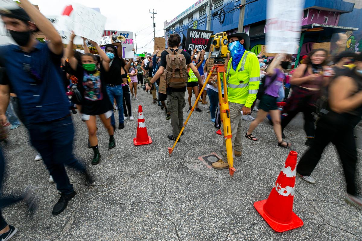 David Silverman, 43, works for a land surveying crew, as activists make their way past him during a Justice for George Floyd rally in MiamiÕs Wynwood neighborhood on Friday, June 5, 2020.