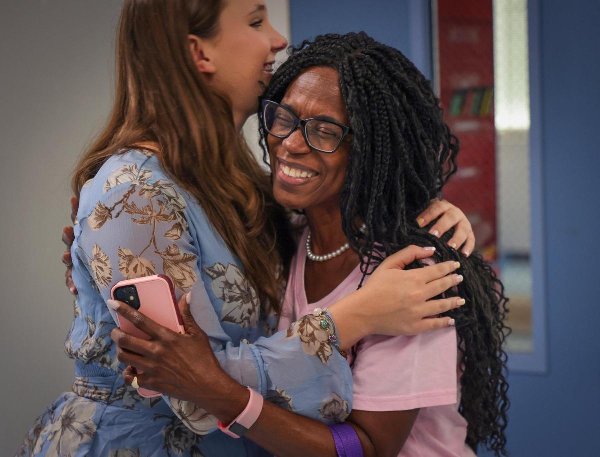 Mina Boomer, left, receives an embrace of gratitude from Media Specialist Constance Gilbert after she and her father delivered supplies to the students of Dorothy M. Wallace Cope Center in south Miami-Dade. Mina is an 8th grade student who started a service project to help teen moms in Miami by donating items they needed.