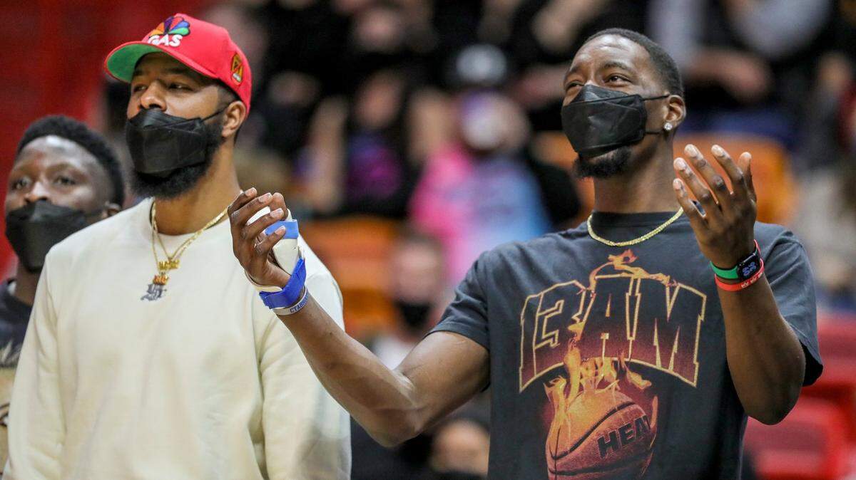 El centro de Miami Heat, Bam Adebayo (13), reacciona desde el banco mientras él y sus compañeros usan máscaras protectoras mientras ven al Miami Heat pelear contra los Washington Wizards en el último cuarto en FTX Arena en Miami el martes 28 de diciembre de 2021.