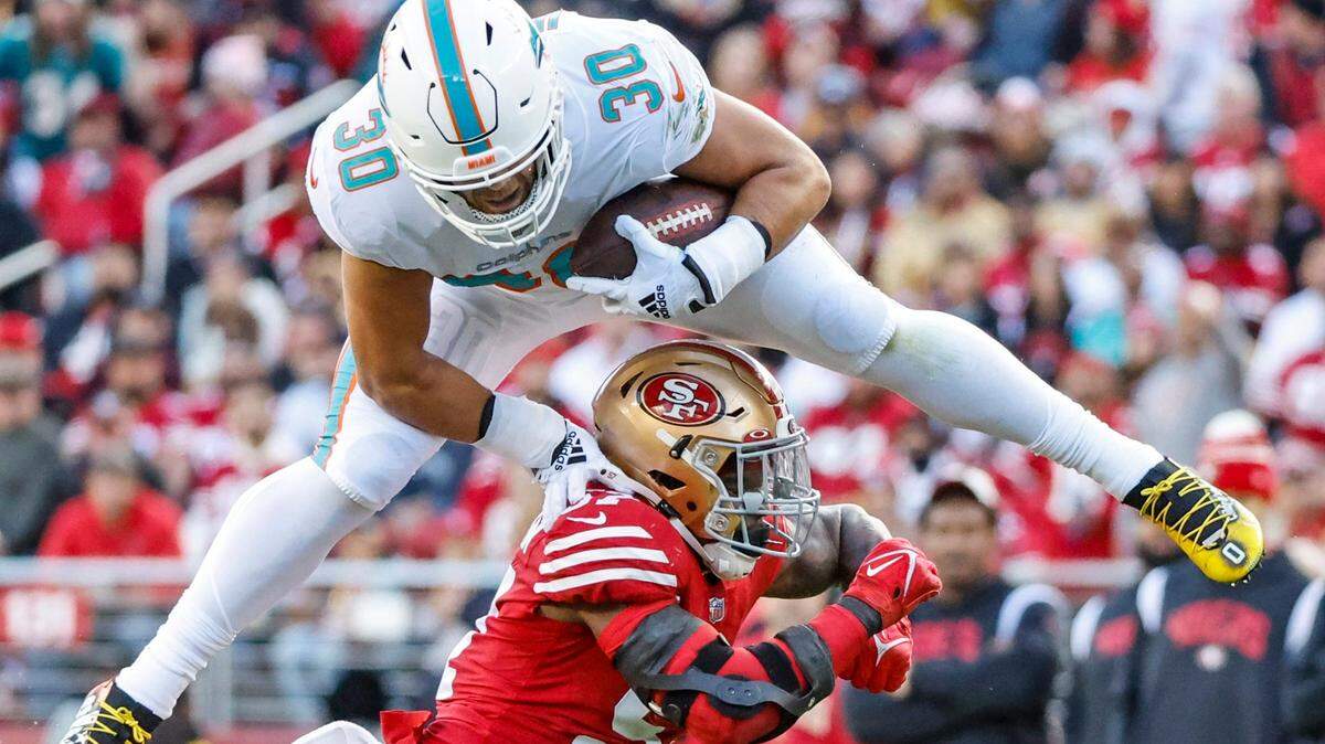 Miami Dolphins fullback Alec Ingold (30) hurdles over San Francisco 49ers linebacker Dre Greenlaw (57) in the second quarter for a first down at Levi’s Stadium in Santa Clara, California on Sunday, December 4, 2022.