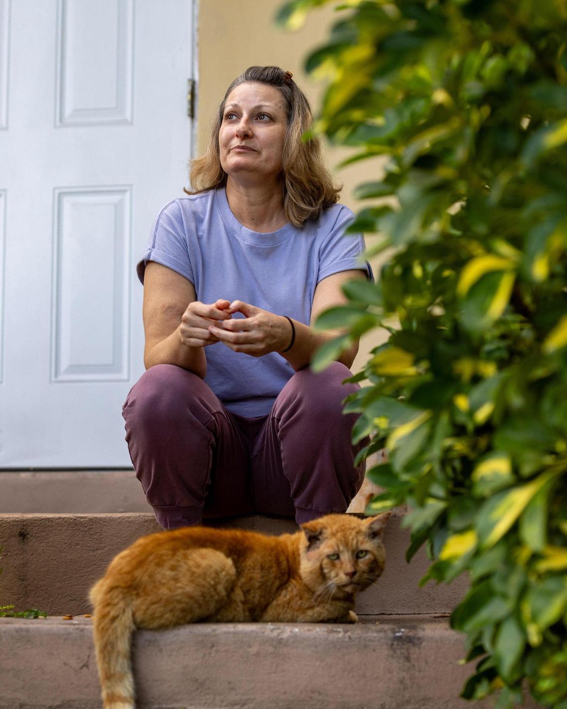Katrina Faust, who has multiple sclerosis, sits on the porch outside her home in North Miami.