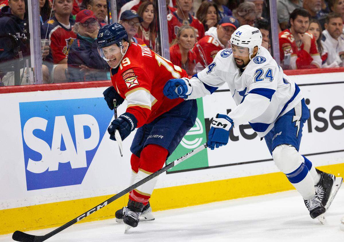 Florida Panthers left wing Matthew Tkachuk (19) and Tampa Bay Lightning defenseman Mathew Dumba (24) go for the puck during the second period of Game 1 of the Stanley Cup Playoffs Round 1 on Sunday, April 21, 2024, at Amerant Bank Arena in Sunrise, Fla. The score was 1-1 at the end of the second period.