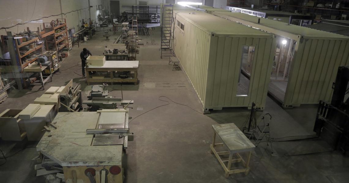 The view of the work space at the Little River Box Company, 9200 NW 27th Ave., Miami.  Homes under construction using cargo containers are visible to the right.