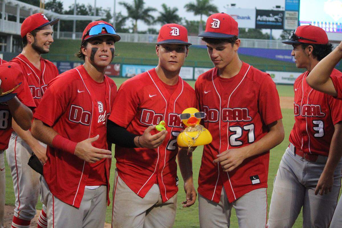Doral baseball players celebrate holding “Quackson,” a toy duck they brought to every game and kept as part of their celebrations when they scored runs.