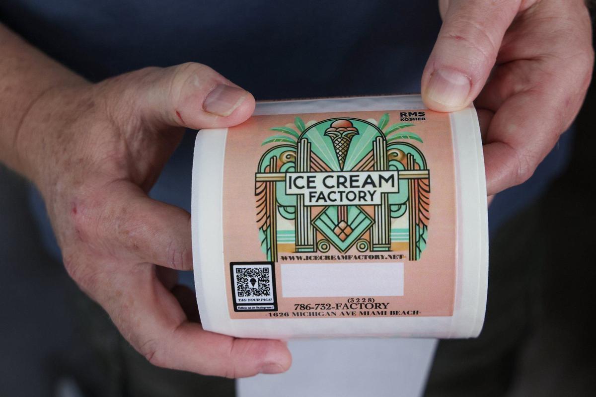 Sam Brejt holds new labels with The Ice Cream Factory’s new logo on them at the shop in Miami Beach. The shop also sells ice cream by the pint.