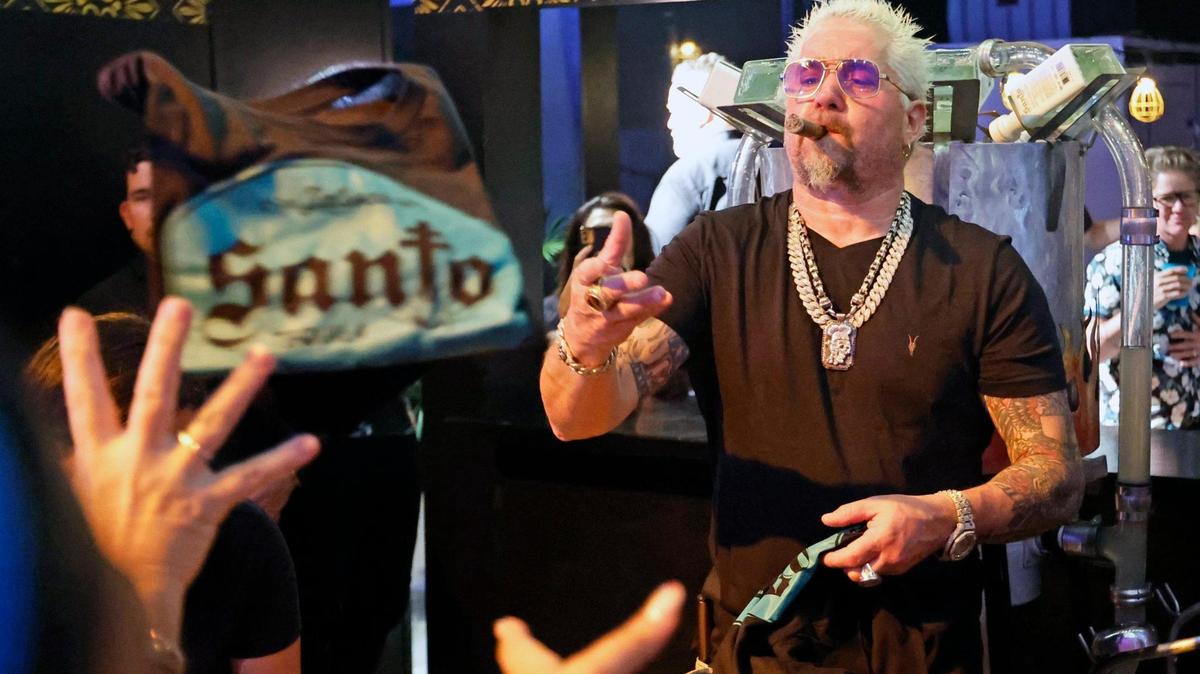 Guy Fieri, chef and Food Network celebrity, hands out Santo Tequila T-shirts at the South Beach Wine & Food Festival on the sand by the Ritz Carlton in Miami Beach, Florida on Friday, February 24, 2023.