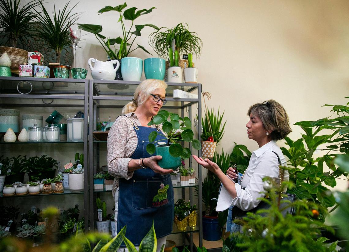 Erica des Roches, the owner of Veranda Plants & Gifts, helps customer Eileen Peñate, right, at Roches’ store on Miracle Mile in Coral Gables, Florida on Friday, December 10, 2021.