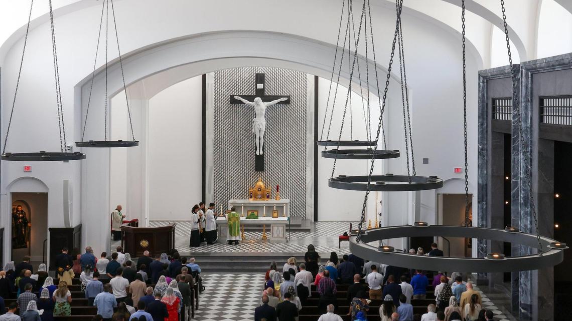Monseñor Oscar Castañeda (en el centro) dirigiendo la misa en latín frente a la gran cruz en el interior de la capilla de Nuestra Señora de Belén, mientras el servicio atraía a jóvenes fieles y familias el domingo 30 de julio de 2023.