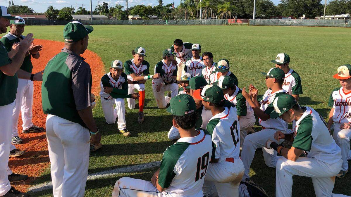 McArthur baseball coach Oddibe McDowell (left) speaks to his team following the Mustangs 5-0 victory over Mater Academy in a Class 8A Regional Quarterfinal game on Thursday at McArthur High.