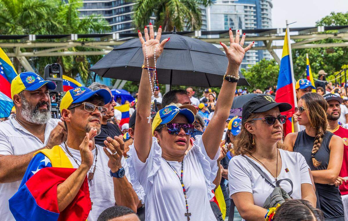 Protestors react to speakers on stage during the protest in the Amphitheater at Bayfront Park in downtown Miami.