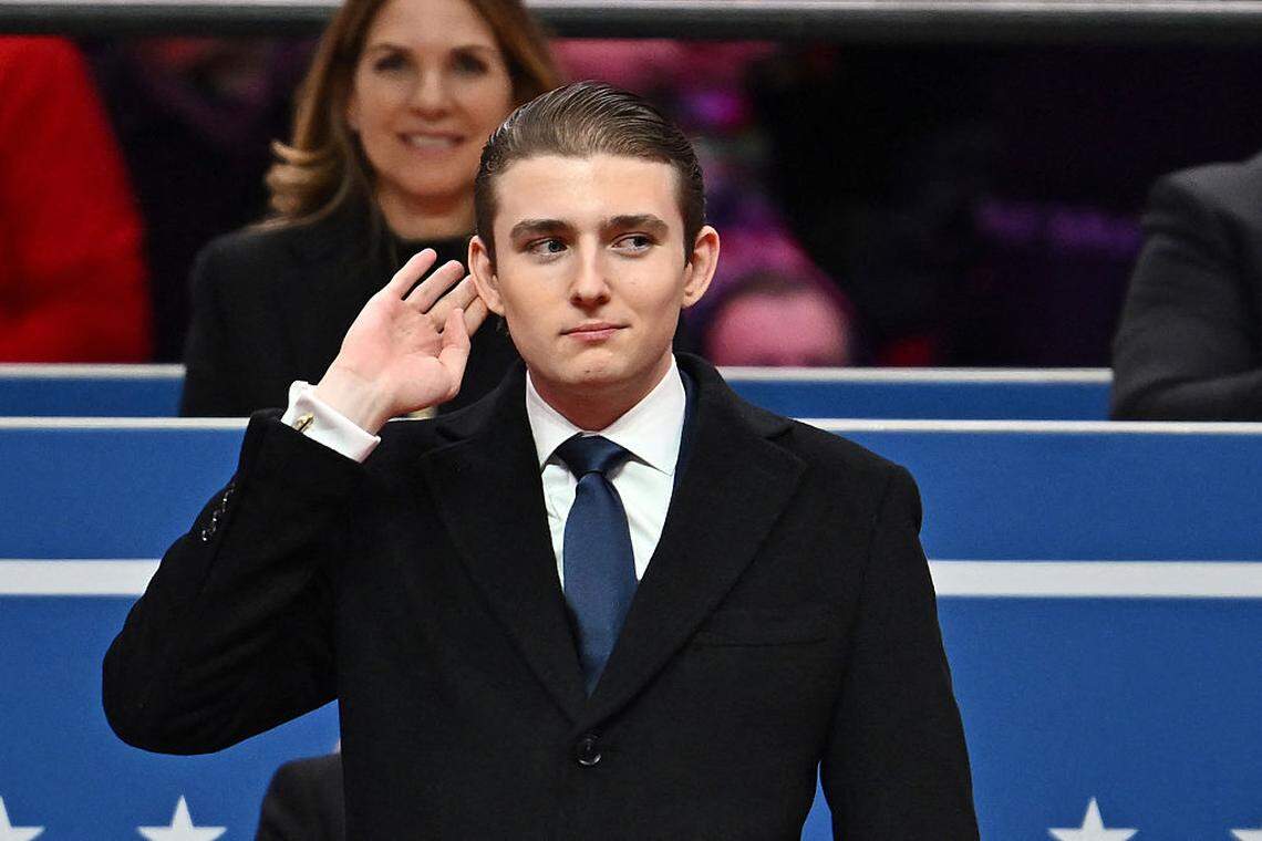 Barron Trump gestures after being acknowledged by his father US President Donald Trump during the inaugural parade inside Capital One Arena, in Washington, DC, on January 20, 2025. 