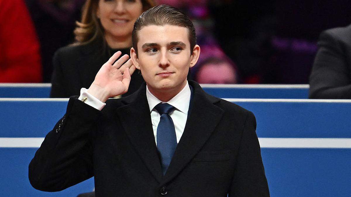 Barron Trump gestures after being acknowledged by his father US President Donald Trump during the inaugural parade inside Capital One Arena, in Washington, DC, on Jan. 20, 2025. 