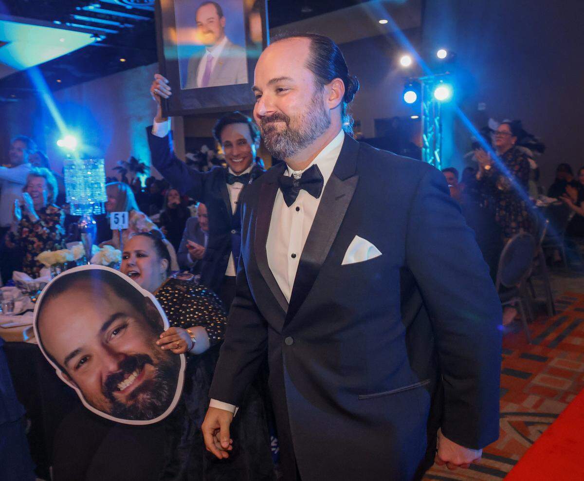 Dale J. Adamson, center, heads to the stage after being named the 2027 Francisco R. Walker Runner-Up Teacher of the Year at the DoubleTree by Hilton Hotel Miami Airport & Convention Center, in Miami, Florida.