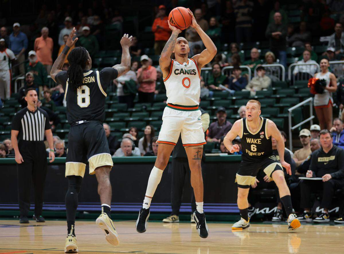 Jan 11, 2025; Coral Gables, Florida, USA; Miami Hurricanes guard Matthew Cleveland (0) shoots the basketball over Wake Forest Demon Deacons guard Ty-Laur Johnson (8) during the first half at Watsco Center. Mandatory Credit: Sam Navarro-Imagn Images