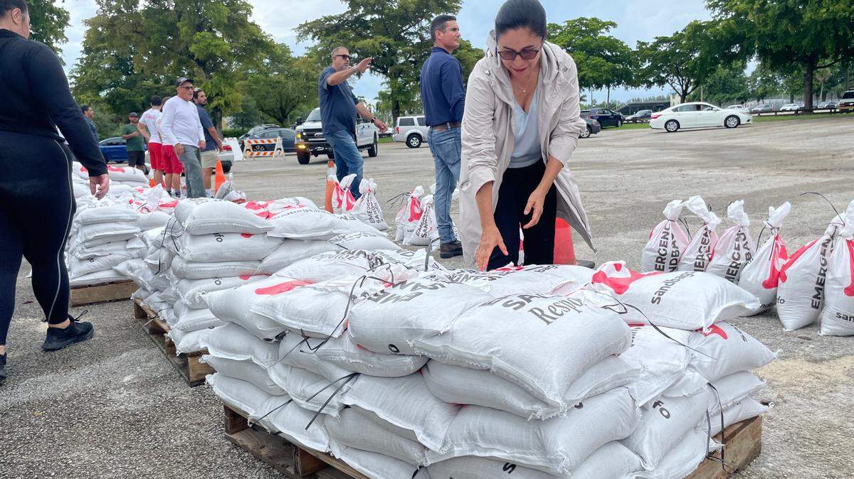 Maria Nardi, director of the Miami-Dade County Parks and Recreation Department, helps with sandbag distribution at Tropical Park on Monday, Oct. 7, 2024. The county launched the bag distribution as Hurricane Milton threatened Florida and was forecast to bring the potential for heavy rain to the Miami area.
