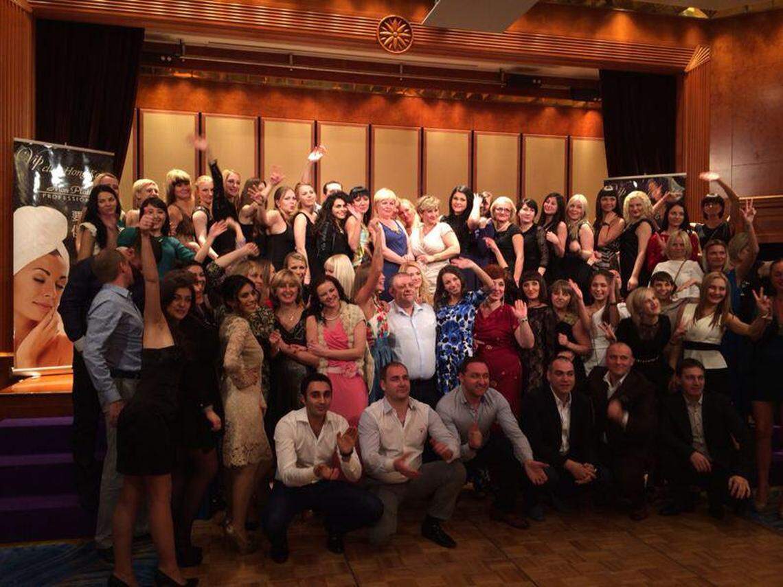 Mark Allayev, crouched down in a white shirt in the front row, at an annual retreat for Mon Platin, an Israeli line of beauty products.