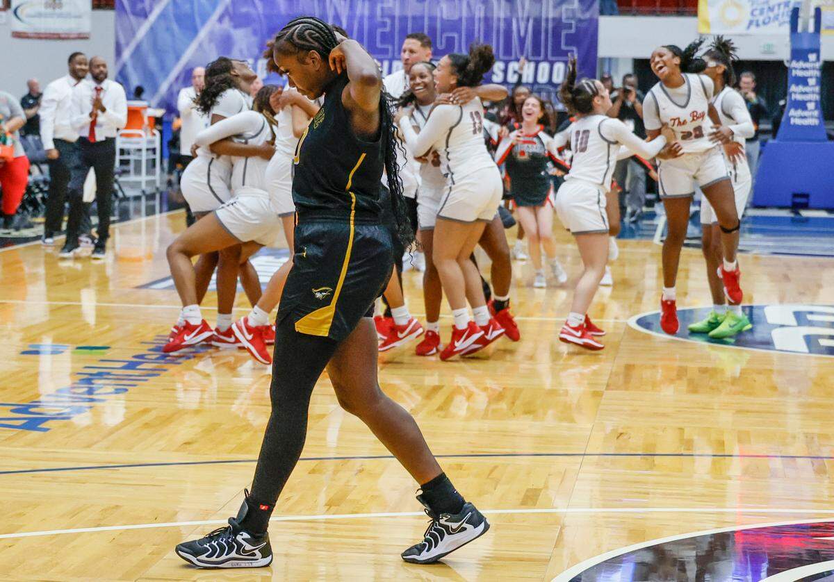 American Heritage’s Dezuray McGill (30) walks off the court as Palm Bay celebrates the winning the FHSAA Class 4A Girls High School Basketball State Championship