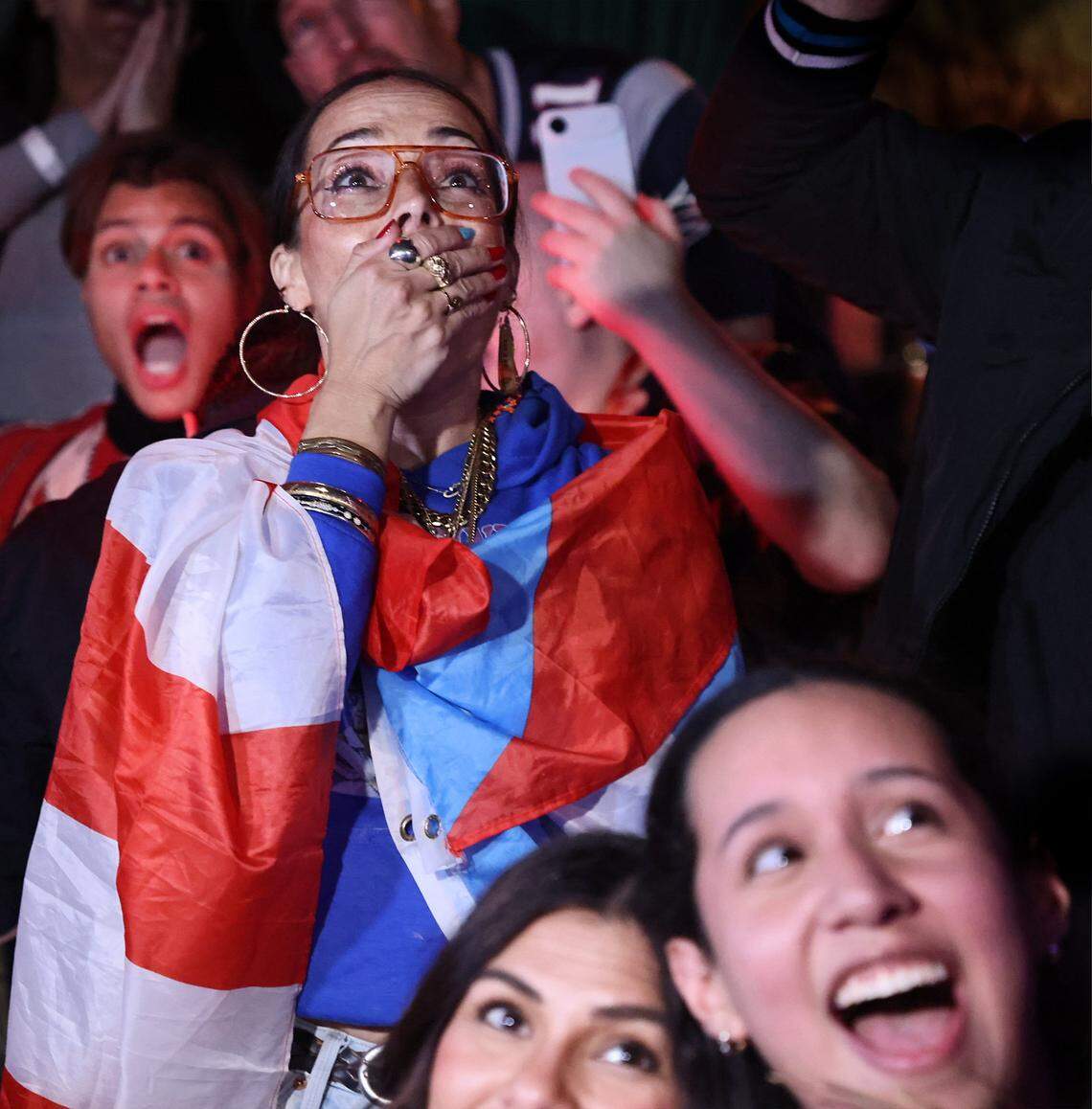 Tara Fougner (center) cannot contain her excitement while draped with a Puerto Rican flag as Bad Bunny starts his show at the ‘Benito Bowl’ party at Dead Flamingo. 