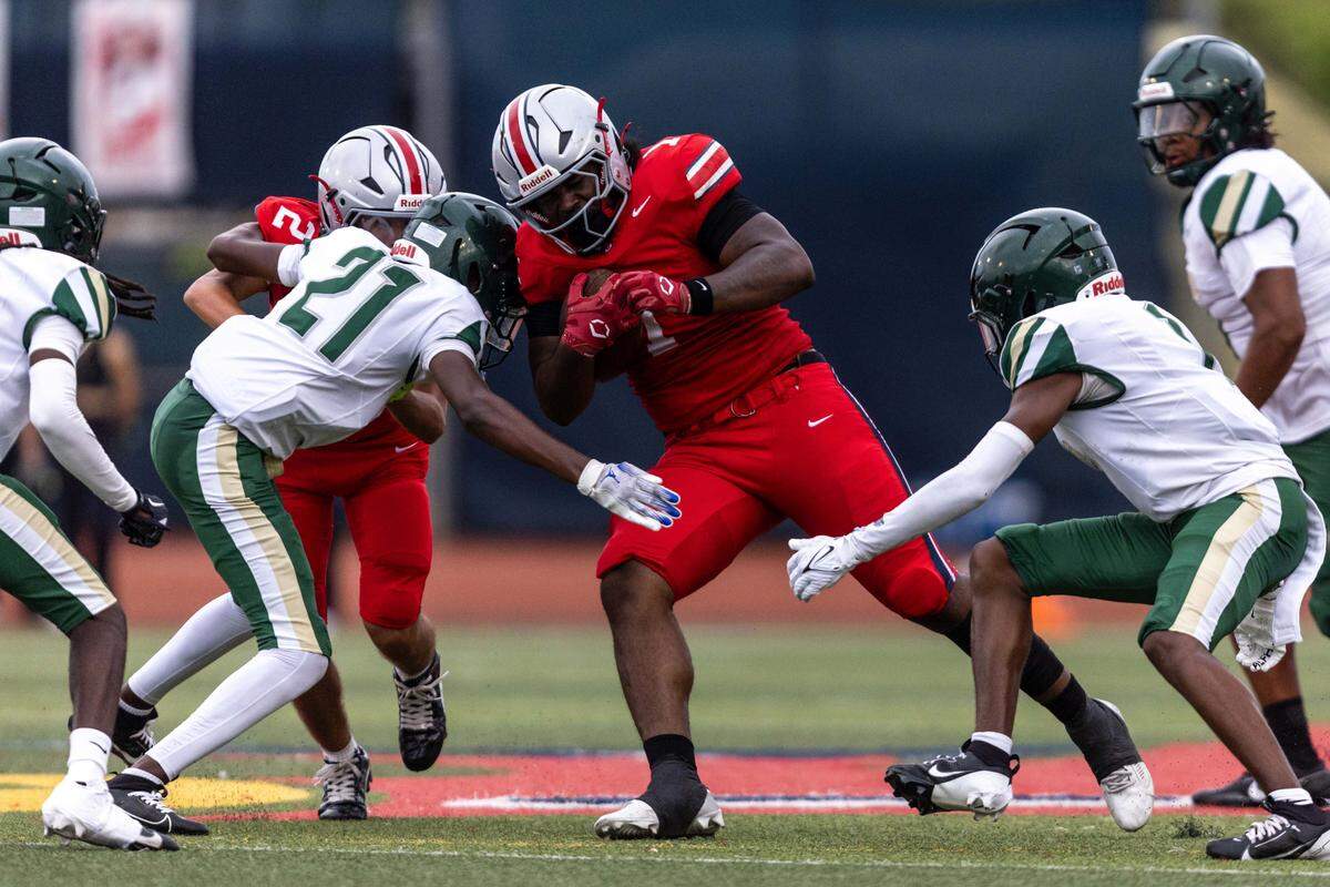 Doral Academy running back Darreon Green (1) lowers his shoulder as he runs with the ball and is tackled by Mater Academy cornerback Naszir Maximin (21) during the first half of a high school football game at Doral Academy on Thursday, August 28, 2025, in Doral, Fla.