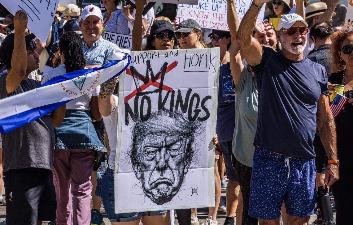 Protesters with signs at the Miami Torch of Friendship in downtown Miami during the ‘No Kings’ anti-Trump protests on Oct. 18, 2025.