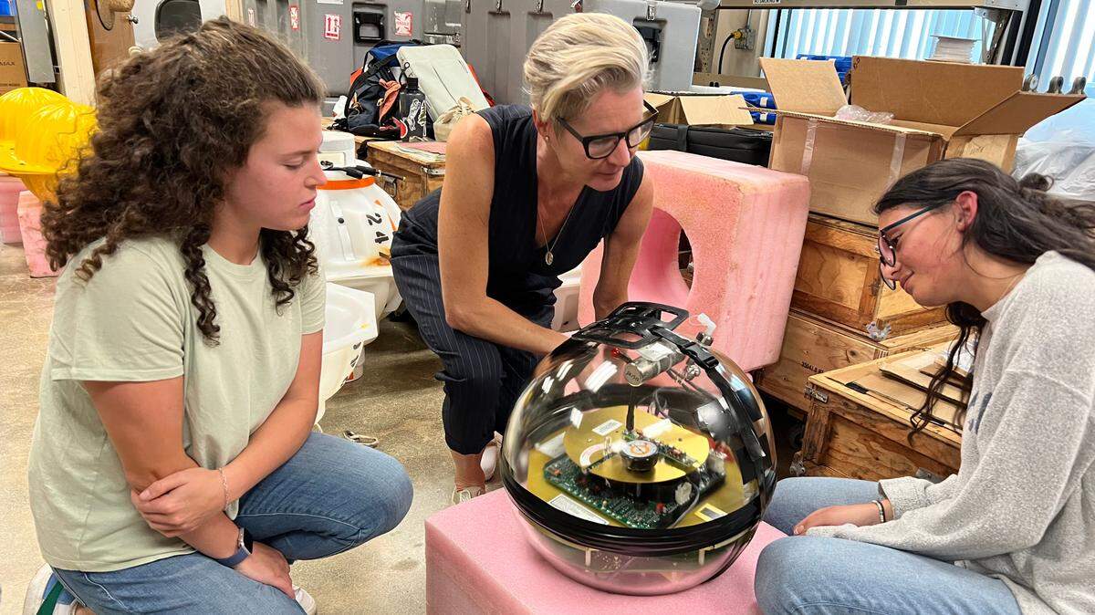 Lisa Beal, professor of ocean sciences at the University of Miami Rosenstiel School, (center) shows one of the sensors that will monitor the Florida Current to undergraduate oceanography students.