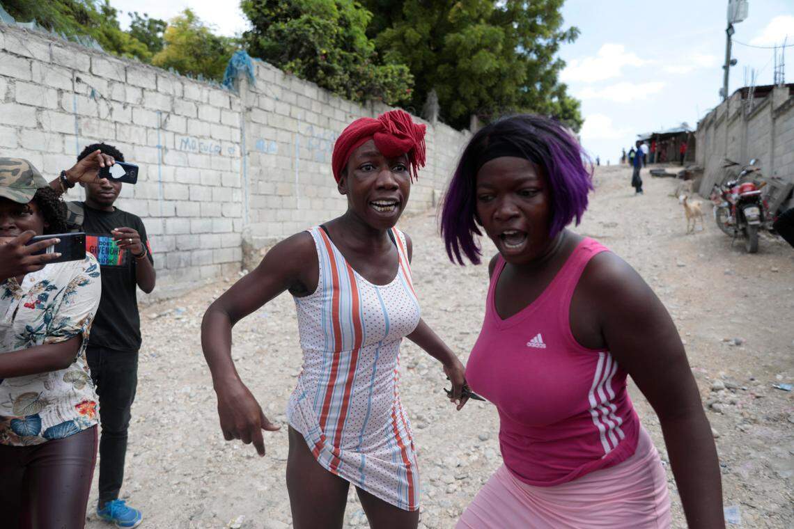 Relatives of Haitian churchgoers killed during a religious march the day before express their anger Sunday in front of the church.