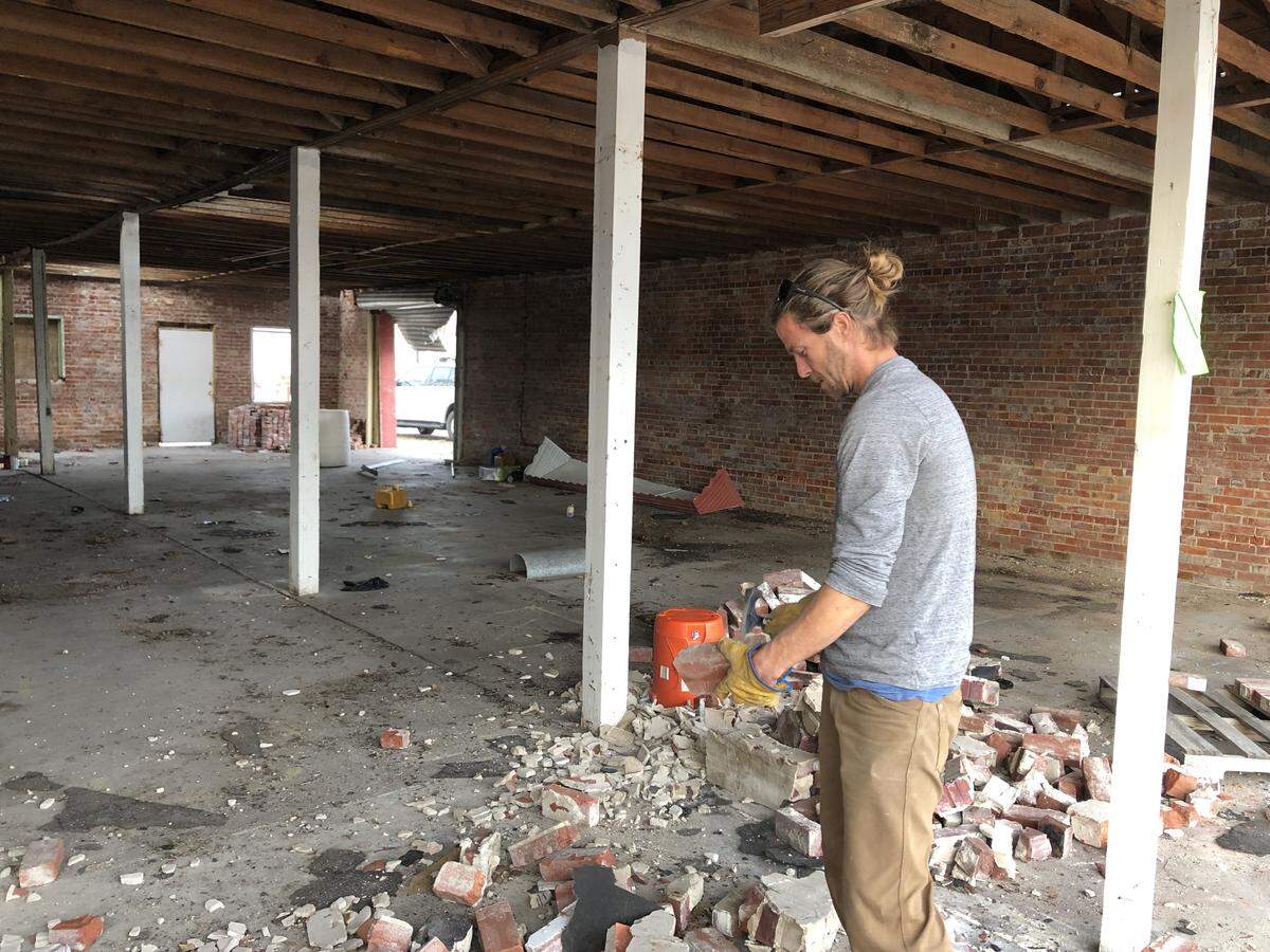 Michael Nordness, 33, works to salvage bricks from the street in front of his brother-in-law’s property, where a wall was knocked down by Hurricane Michael in October.