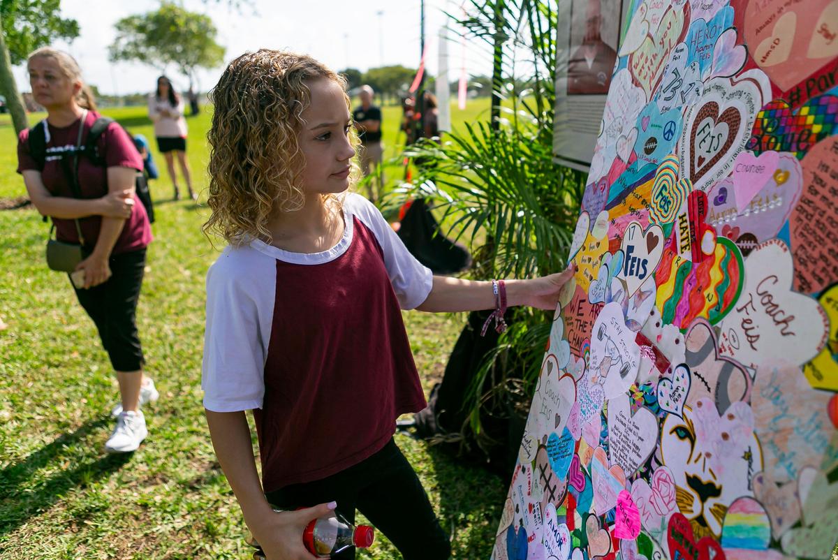 Maci Norkunas looks at a collage of art honoring the 17 victims killed at the Marjory Stoneman Douglas High School shooting. The art piece was on display at Pine Trails Park during the two-year anniversary of the shooting in Parkland, Florida, on Friday, February 14, 2020.